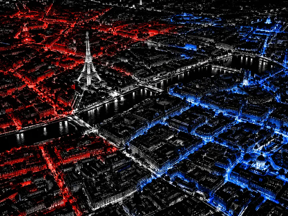 Paris de nuit vu du ciel, quartiers en rouge et bleu selon les clans